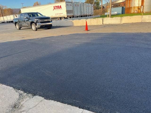 Freshly patched section of a commercial parking lot at a business site by R. Stanley's Paving.