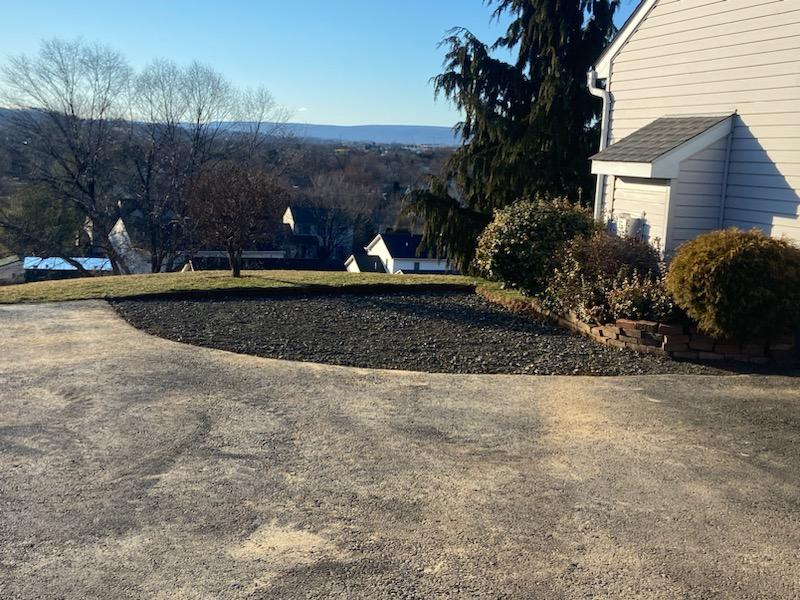 A faded gray asphalt driveway that is due for seal coating