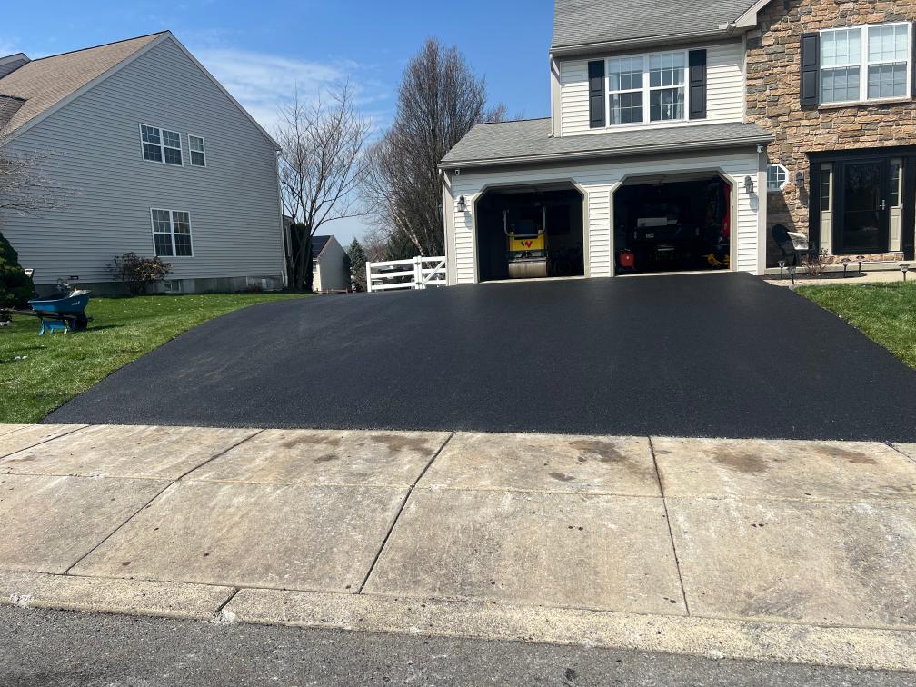 Driveway extension and resurfacing finished in fresh asphalt at a two-car garage home in the Reading area.
